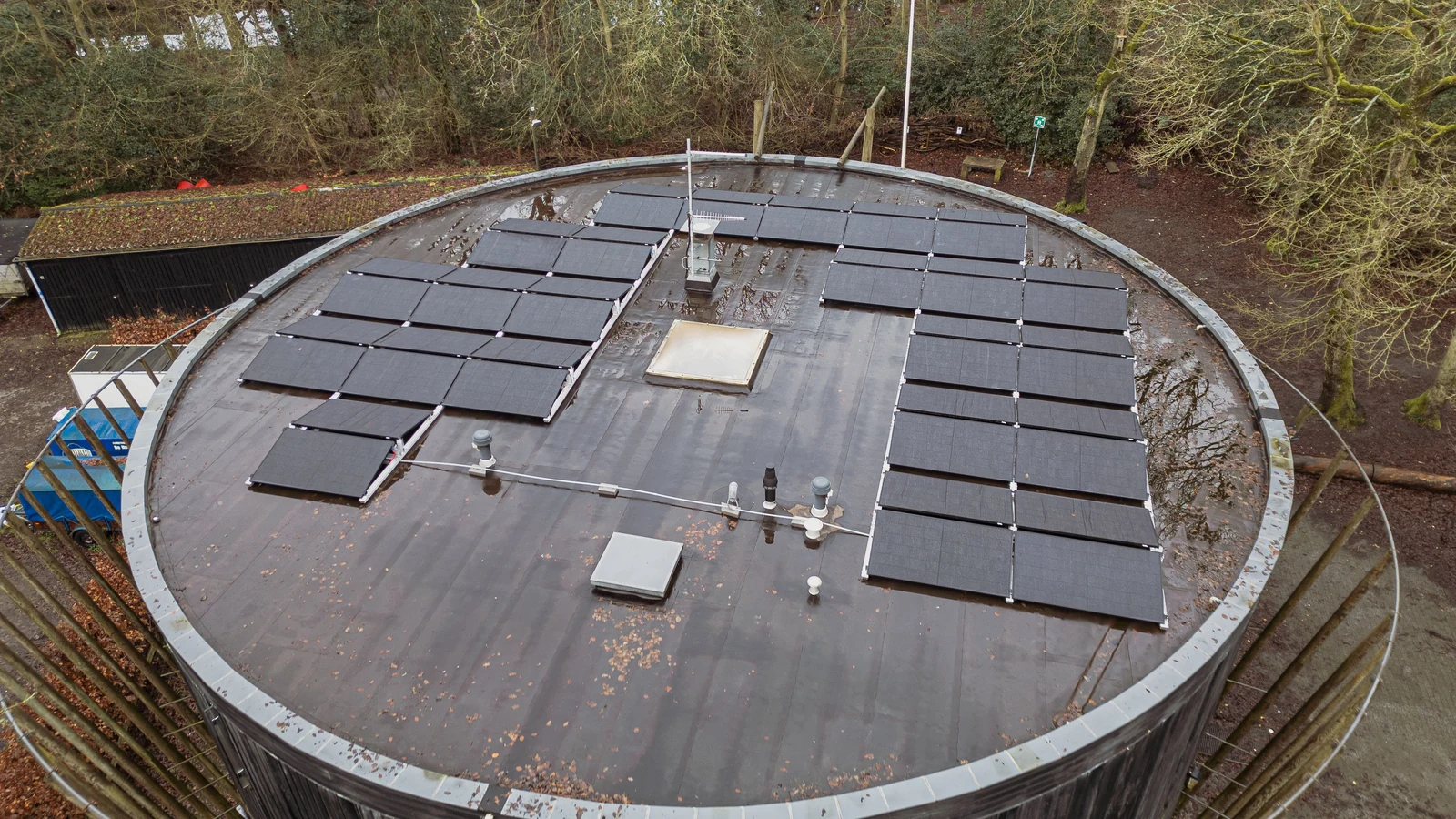 Bâtiment solaire dans un paysage végétalisé Bâtiment entouré de végétation avec une grande installation solaire en toiture