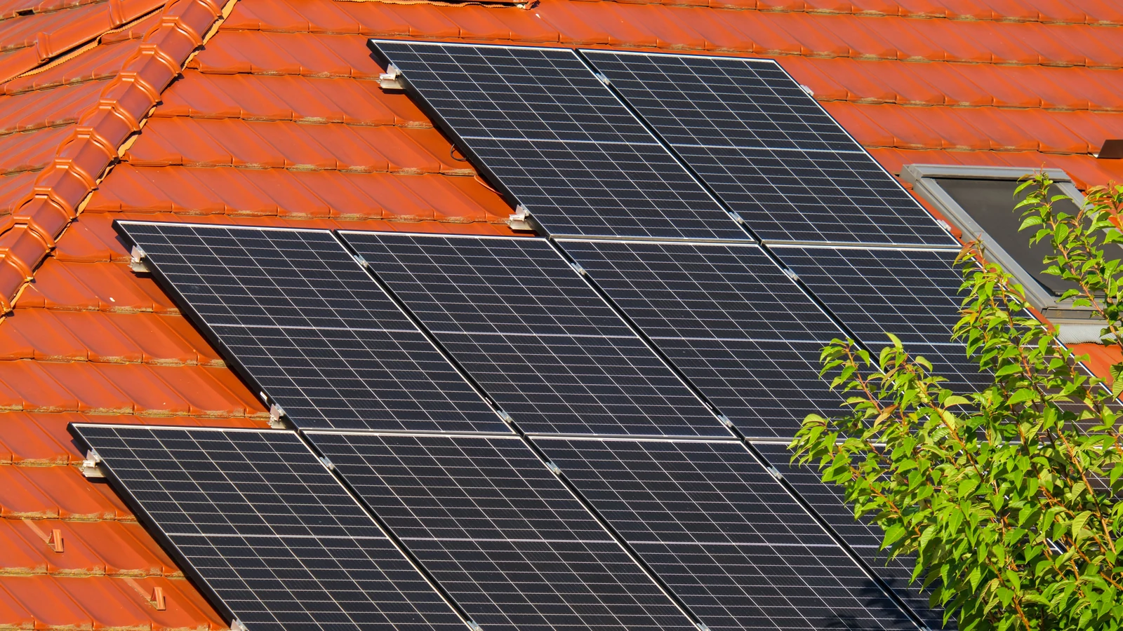 Maison européenne avec panneaux photovoltaïques sur une toiture en tuiles rouges