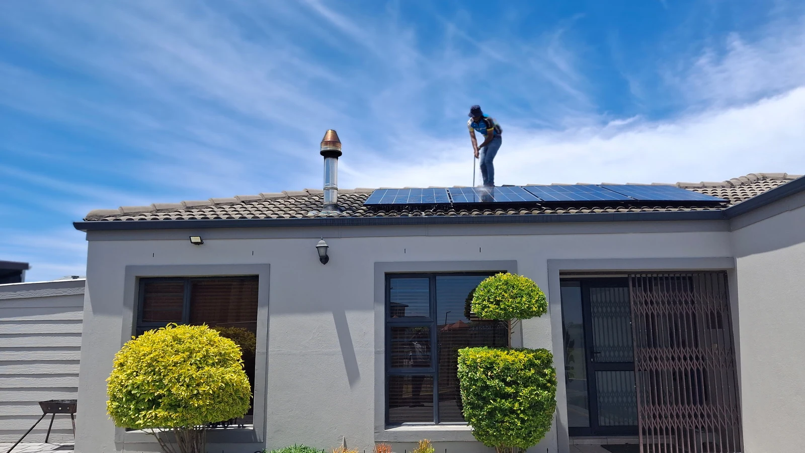 Installateur posant des panneaux photovoltaïques sur la toiture d’une maison